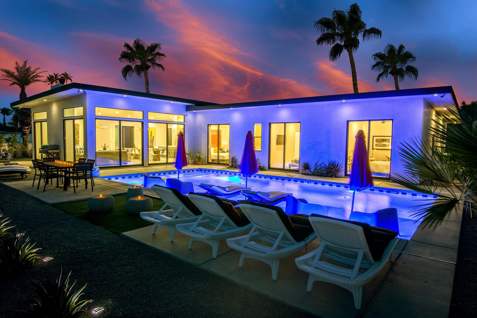 Palms at Park private homes at twilight, with a lit pool, palms, and mountain silhouettes