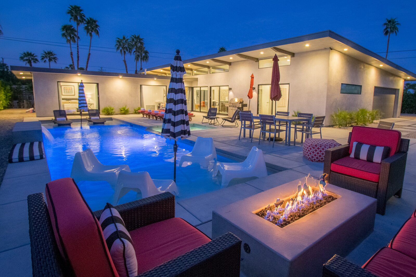 Palms at Park Villa 42-foot saltwater pool at twilight with fire pit and palms